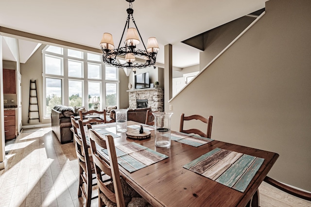 dining area with a chandelier and a stone fireplace