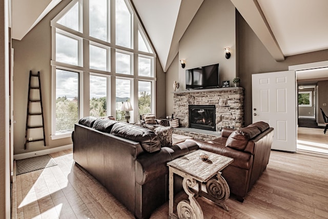 living room with a fireplace, high vaulted ceiling, and light hardwood / wood-style floors