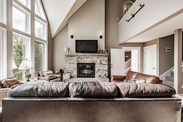 living room featuring a fireplace and high vaulted ceiling