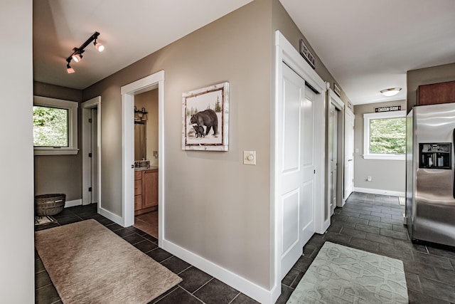 corridor with dark tile patterned floors and rail lighting