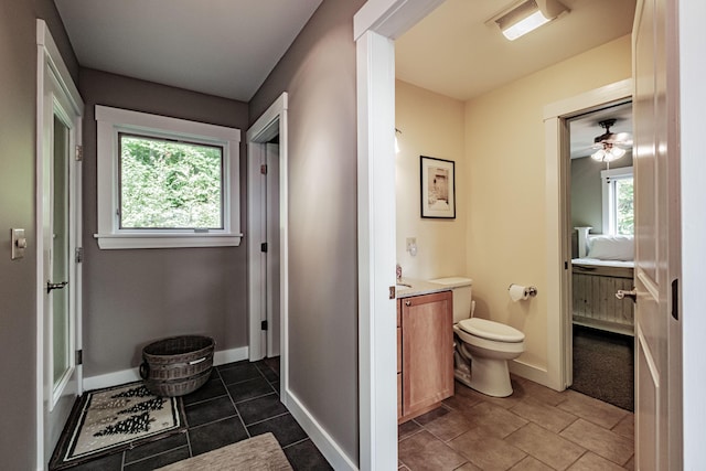 bathroom featuring tile patterned flooring, vanity, toilet, and ceiling fan