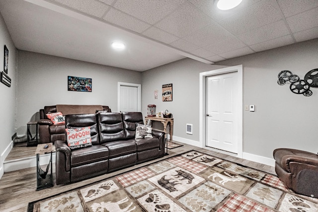 living room with hardwood / wood-style floors and a drop ceiling