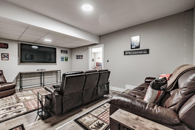 home theater room with a drop ceiling and hardwood / wood-style flooring