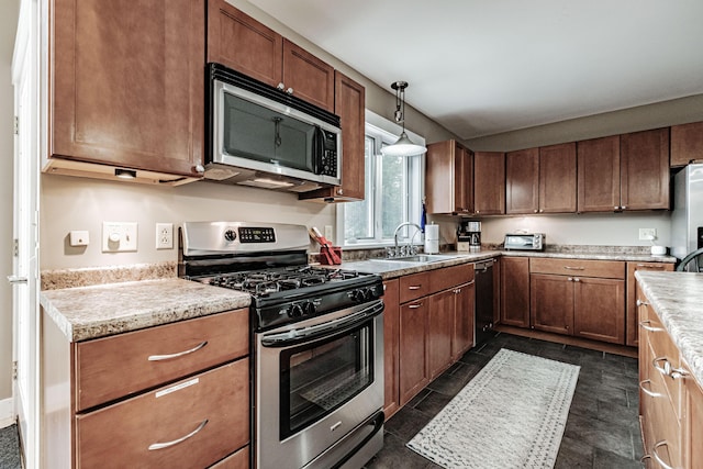 kitchen featuring sink, stainless steel appliances, and decorative light fixtures