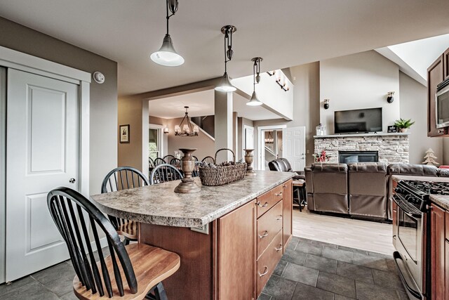 kitchen featuring a kitchen bar, gas range, a kitchen island, and hanging light fixtures