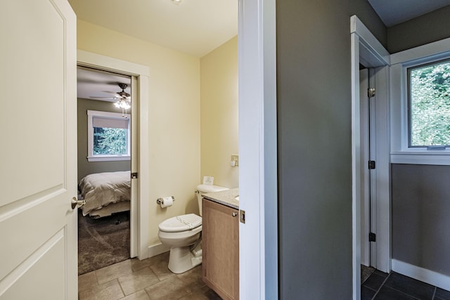 bathroom with tile patterned flooring, vanity, toilet, and ceiling fan