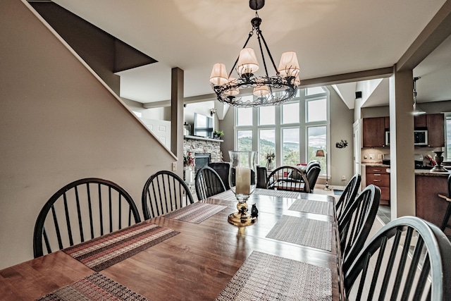 dining area with hardwood / wood-style flooring, a notable chandelier, and a fireplace