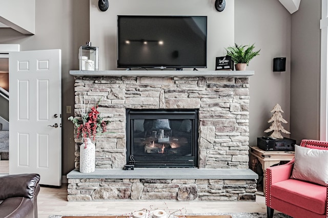 room details featuring a stone fireplace and hardwood / wood-style floors