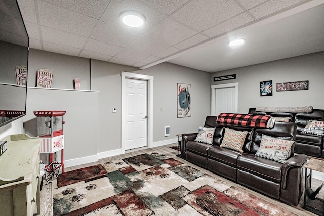 living room featuring a drop ceiling and wood-type flooring