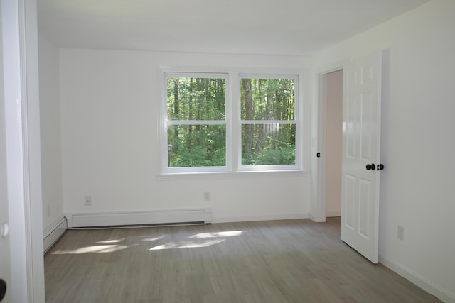 spare room with hardwood / wood-style flooring and baseboard heating