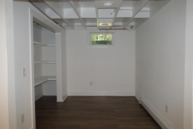 basement featuring dark hardwood / wood-style flooring and a baseboard radiator