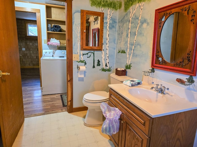 bathroom with vanity, toilet, wood-type flooring, and washing machine and clothes dryer