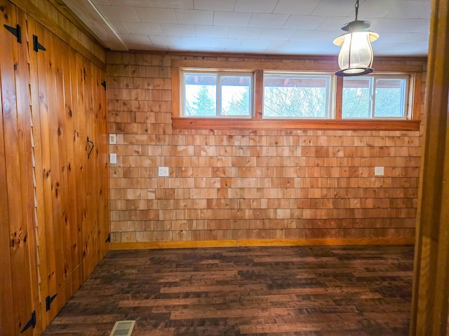 spare room with wood walls and dark hardwood / wood-style flooring