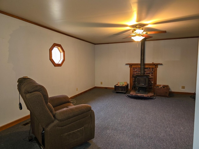 carpeted living room featuring a wood stove, ceiling fan, and ornamental molding