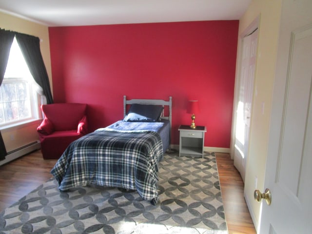 bedroom featuring hardwood / wood-style floors and a baseboard radiator