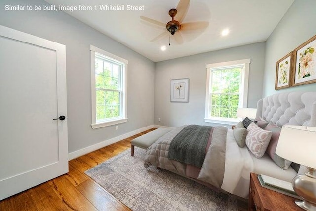 bedroom with multiple windows, ceiling fan, and light hardwood / wood-style flooring