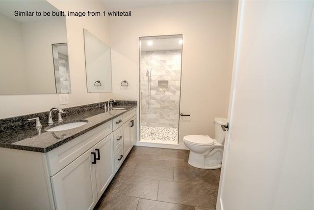 bathroom featuring a tile shower, vanity, and toilet