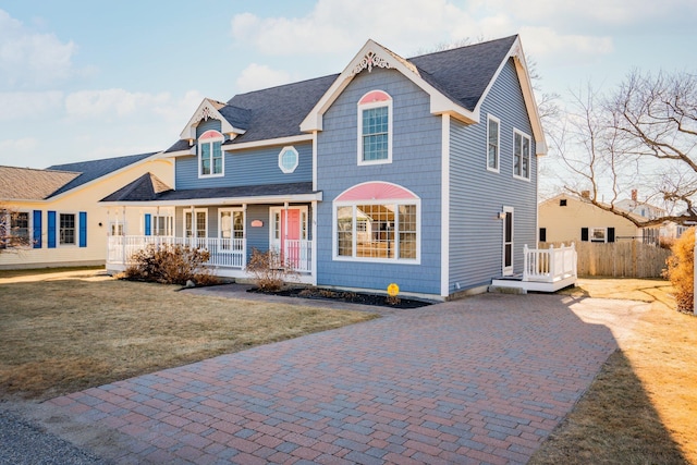 view of front of house with covered porch and a front lawn