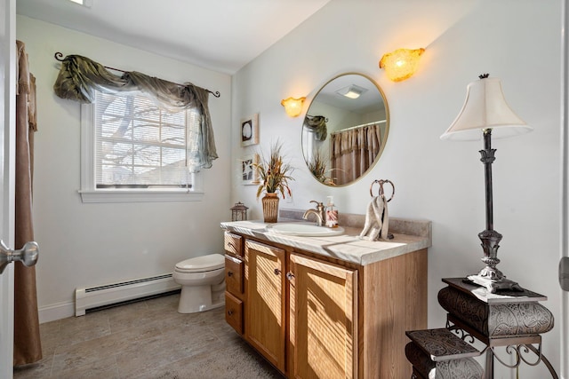 bathroom with toilet, vanity, and a baseboard heating unit