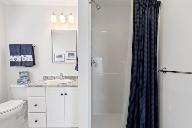 bathroom featuring toilet, curtained shower, and vanity