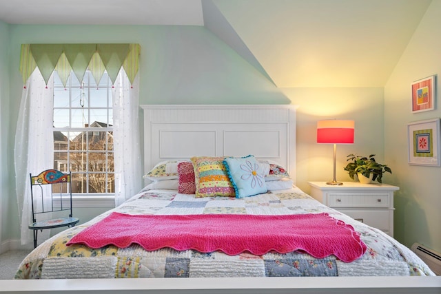 carpeted bedroom with lofted ceiling and a baseboard radiator