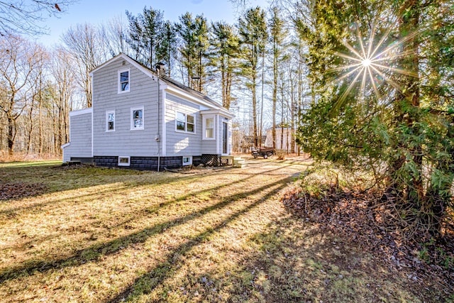 view of side of home with a yard