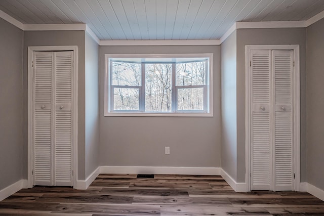 unfurnished bedroom with two closets, dark hardwood / wood-style floors, and wooden ceiling