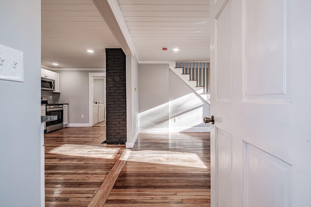 stairway featuring crown molding, wooden ceiling, and hardwood / wood-style flooring