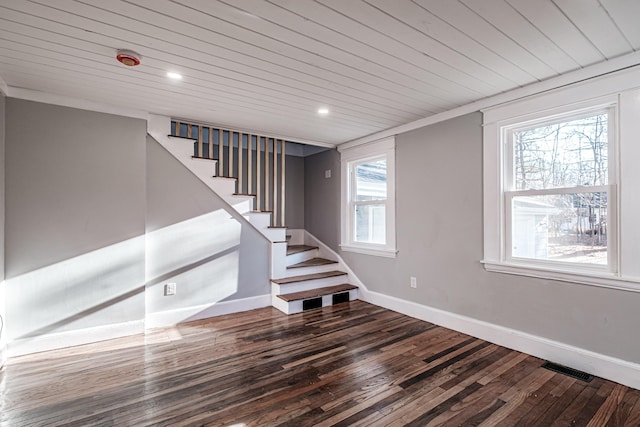 stairs featuring hardwood / wood-style flooring, a healthy amount of sunlight, and wood ceiling