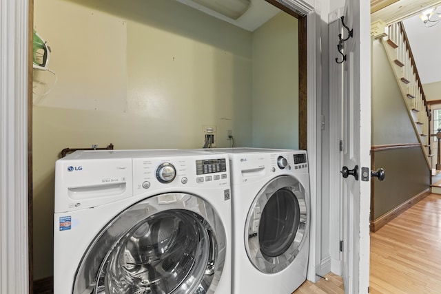 laundry room featuring washing machine and dryer and light hardwood / wood-style flooring