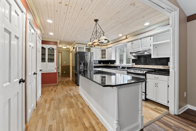 kitchen with wooden ceiling, white cabinets, appliances with stainless steel finishes, light hardwood / wood-style floors, and a kitchen bar