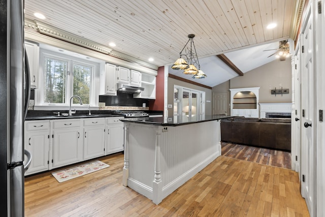 kitchen with white cabinetry, sink, lofted ceiling, and light wood-type flooring