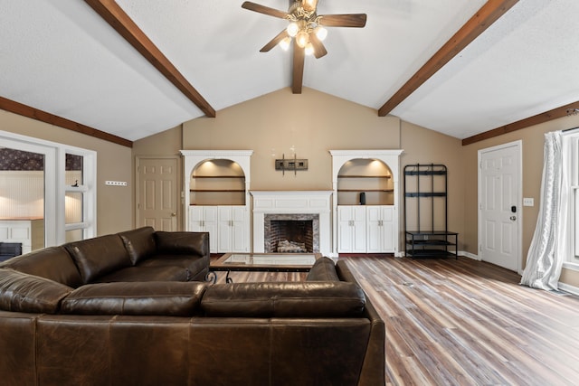 living room with a textured ceiling, lofted ceiling with beams, hardwood / wood-style flooring, and ceiling fan