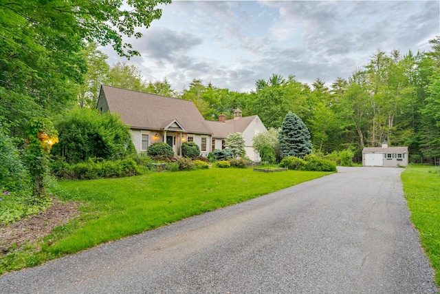 cape cod house featuring an outbuilding and a front lawn