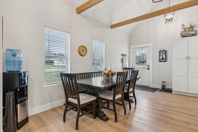 dining space with beam ceiling, light hardwood / wood-style floors, high vaulted ceiling, and a chandelier