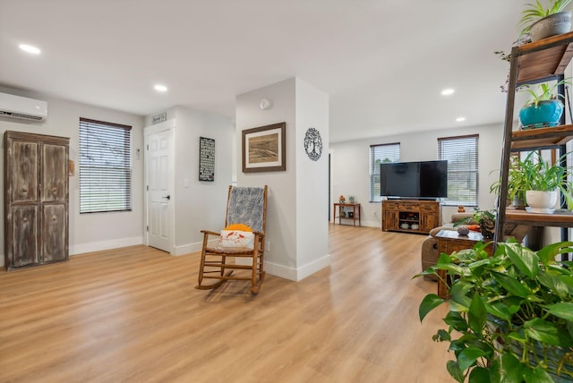 living room with light hardwood / wood-style floors and a wall mounted AC