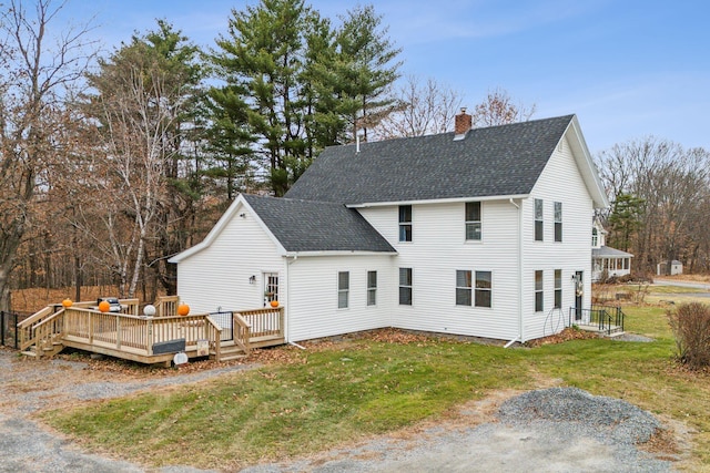 rear view of property featuring a lawn and a deck