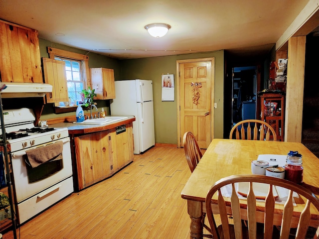 kitchen with white appliances, sink, and light hardwood / wood-style flooring