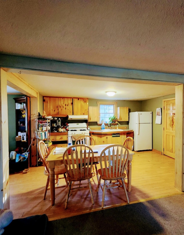 dining area with a textured ceiling and light wood-type flooring