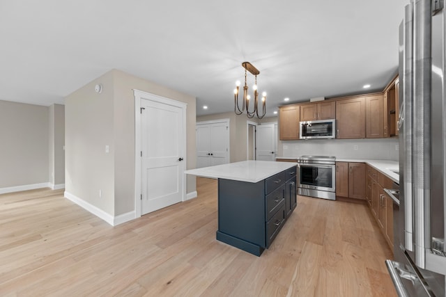 kitchen with light hardwood / wood-style flooring, a chandelier, pendant lighting, a kitchen island, and appliances with stainless steel finishes