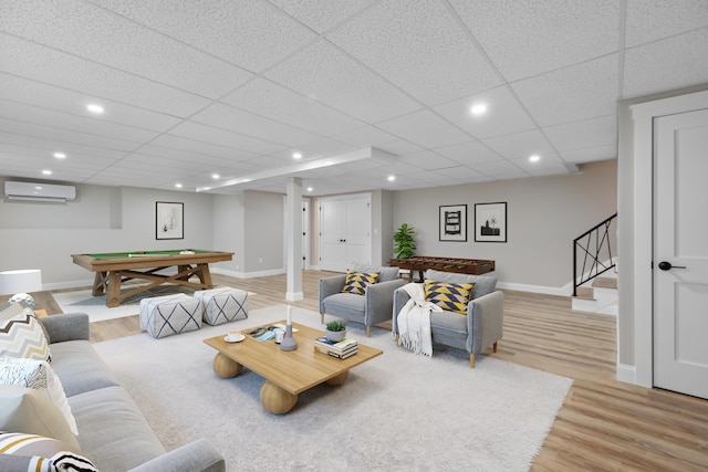 living room featuring a wall mounted air conditioner, a paneled ceiling, billiards, and light hardwood / wood-style flooring