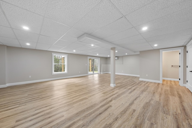 basement featuring light wood-type flooring and a drop ceiling