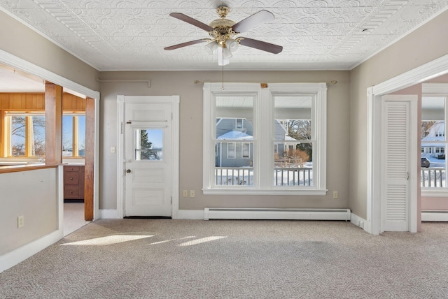 carpeted entryway with a baseboard heating unit, baseboards, and an ornate ceiling