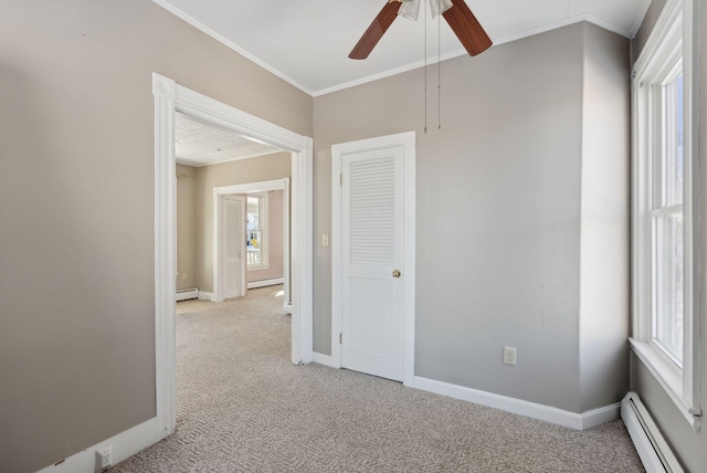 empty room featuring light carpet, crown molding, baseboards, and a baseboard radiator