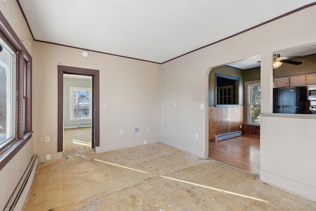 spare room with ornamental molding, baseboards, arched walkways, and a baseboard radiator