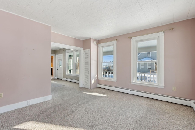 carpeted empty room with plenty of natural light, baseboards, and baseboard heating