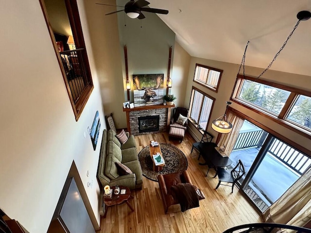 17-3 S Branch Way Unit 35, Sandy River Plt, ME 04970 - living area with high vaulted ceiling, a stone fireplace, a ceiling fan, and wood finished floors