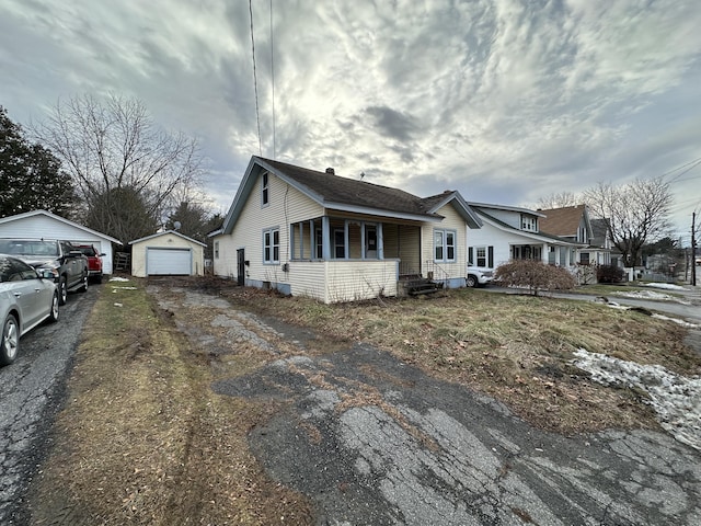 view of side of home featuring a porch, an outdoor structure, and a garage