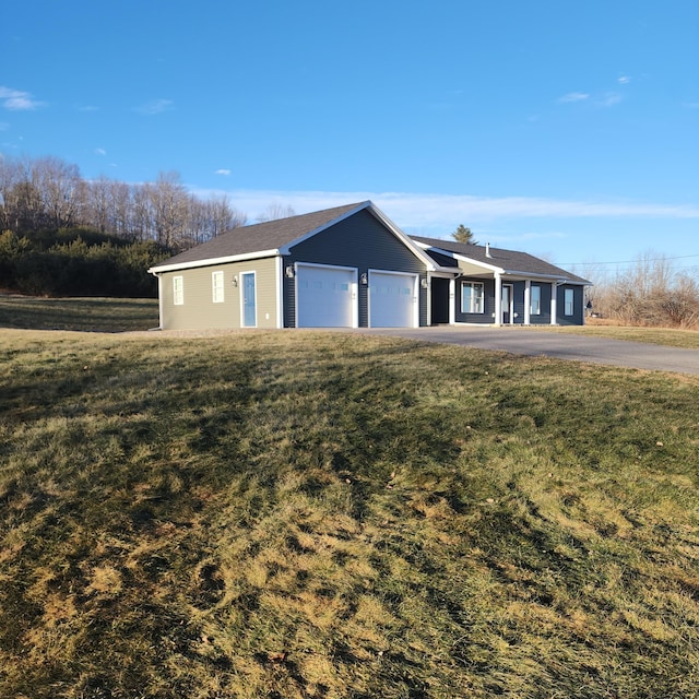 ranch-style house featuring a front yard and a garage