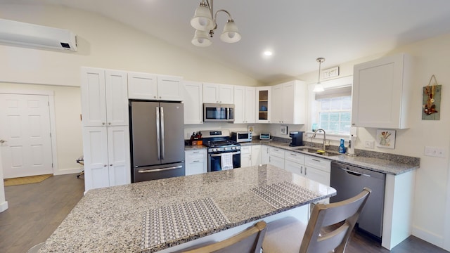 kitchen with sink, decorative light fixtures, light stone counters, white cabinetry, and stainless steel appliances